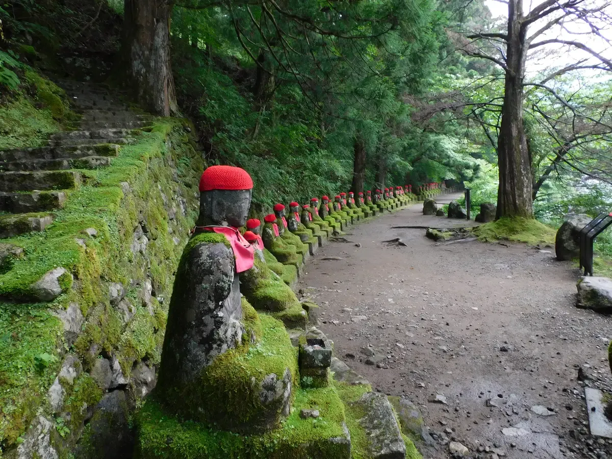 Jizo statues in red caps along the Kanmangafuchi path on a day trip from Tokyo to Nikko